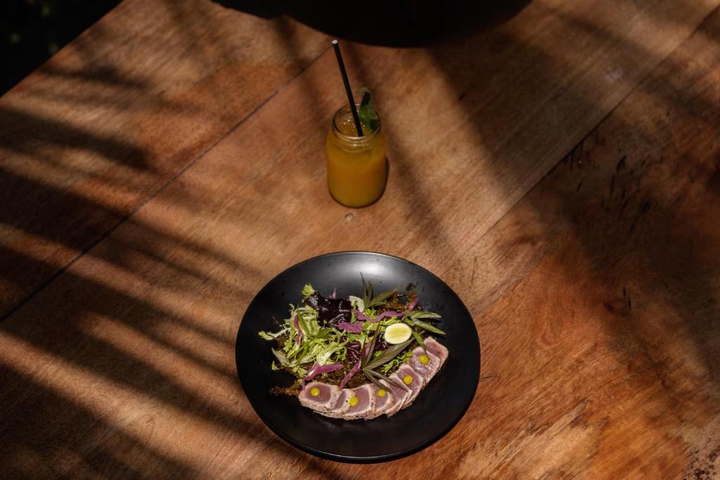 a plate of food on a table with a drink at Mwezi Boutique Resort in Jambiani