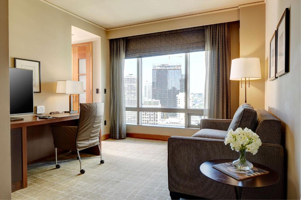 a living room with a couch and a desk in a room at Grand Hyatt Seattle in Seattle