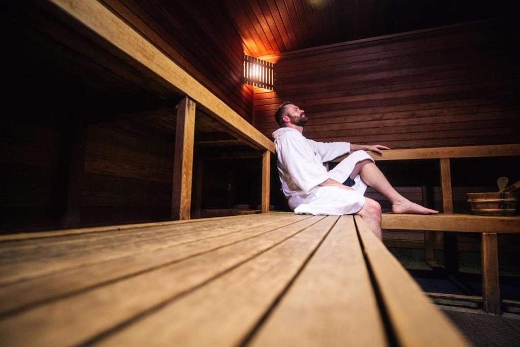 a man is sitting in a sauna at Grand Hyatt Seattle in Seattle