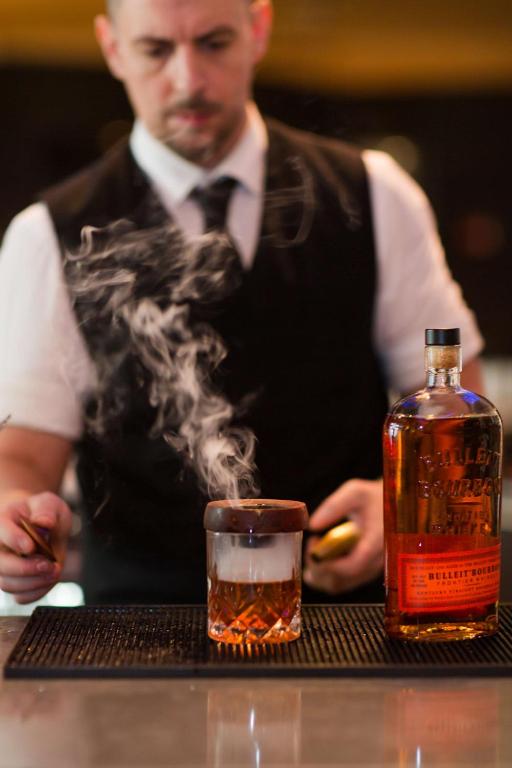 a man in a vest and a bottle of whiskey at Grand Hyatt Seattle in Seattle