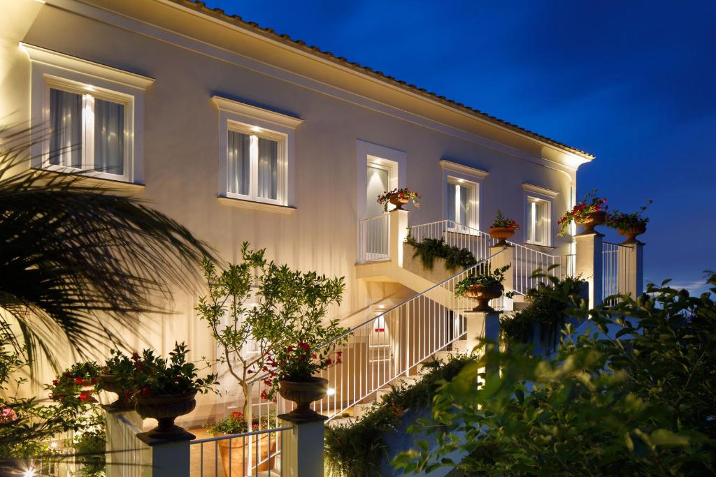 un edificio con macetas en los balcones por la noche en Villa Don Camillo, en Sant'Agnello