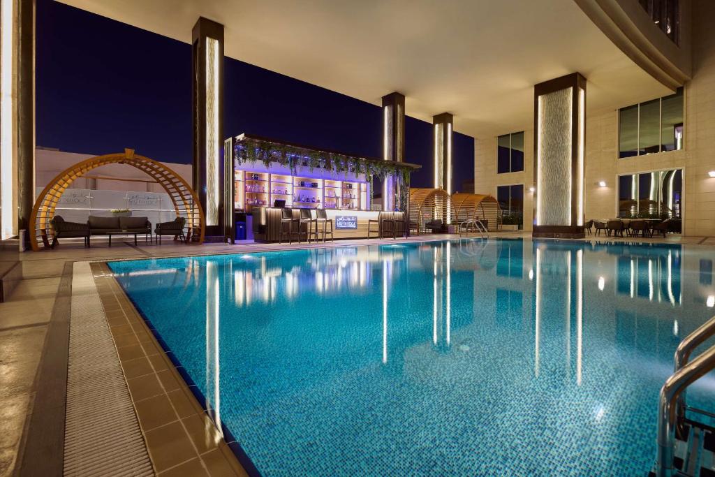 ein Swimmingpool in einem Hotel in der Nacht in der Unterkunft DoubleTree By Hilton Doha - Al Sadd in Doha