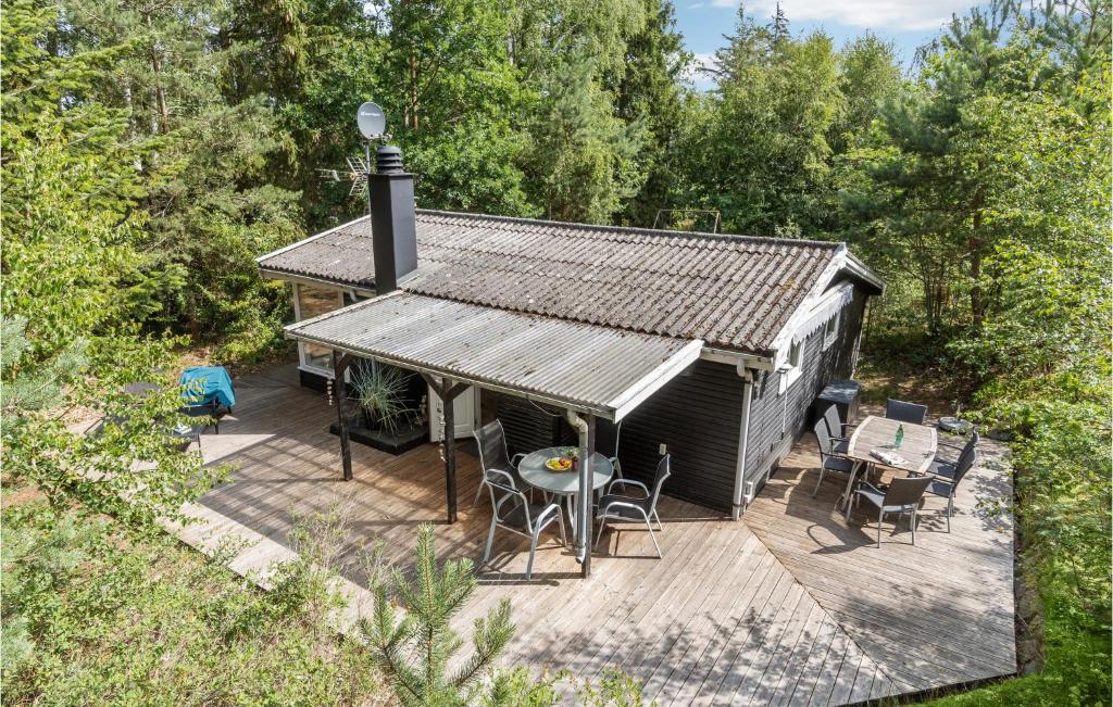 a cabin with a deck with chairs and a table at 2 Bedroom Amazing Home In Nexø in Neksø