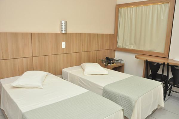 Habitación con 2 camas, mesa y escritorio. en Hotel Maestro Executive Toledo, en Toledo
