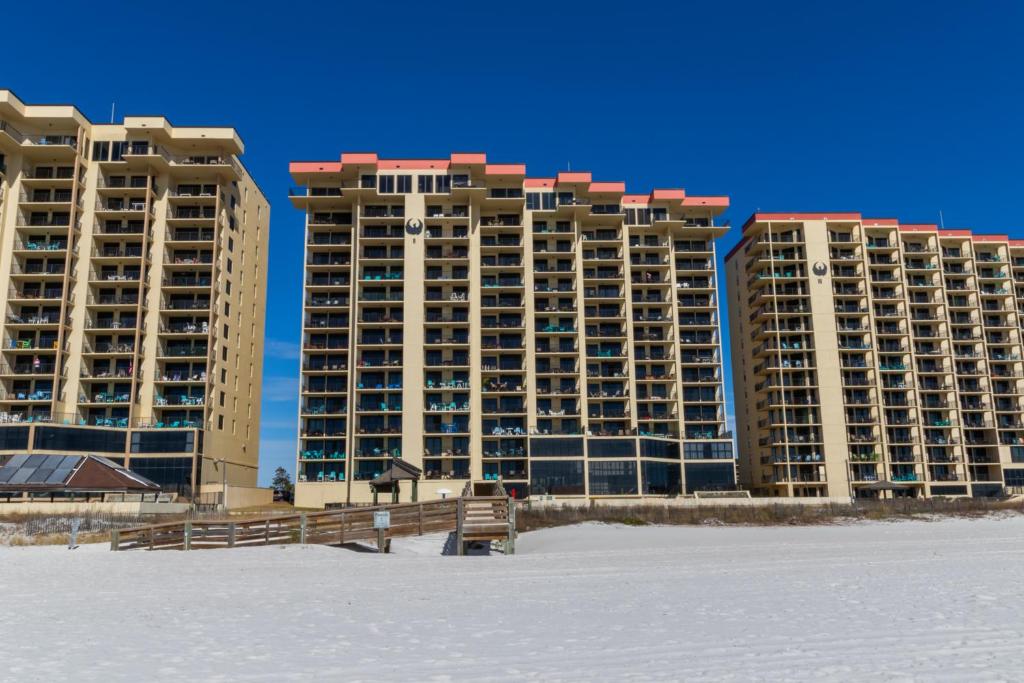 zwei große Apartmentgebäude am Strand mit dem Schnee in der Unterkunft Phoenix II Vacation Condos in Orange Beach