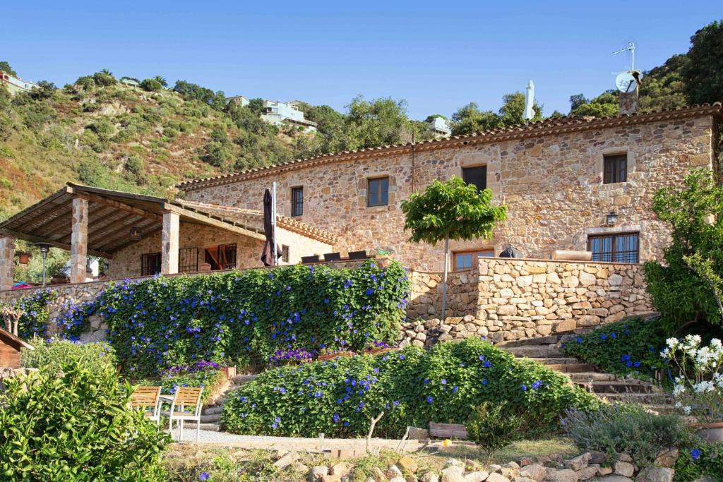 een stenen gebouw met bloemen ervoor bij B&B La Vista Brava in Platja  d'Aro