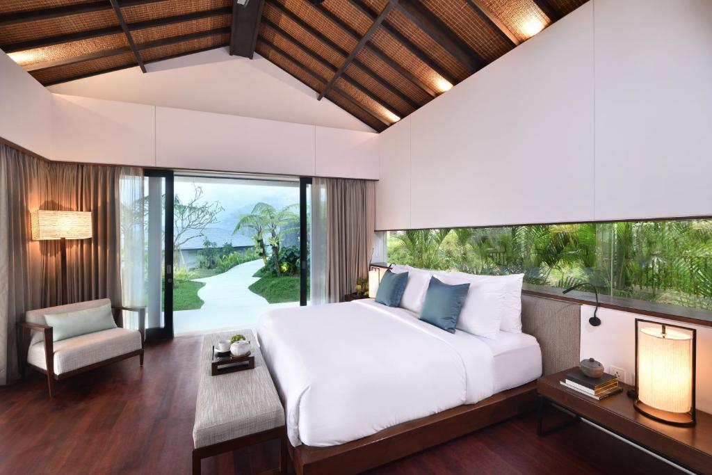 a bedroom with a bed and a large window at Alta Vista Mountain Villa Bali in Gitgit