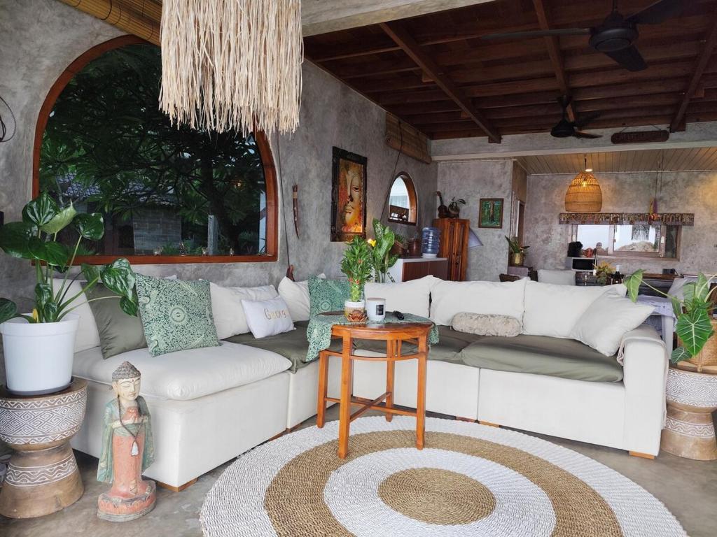 a living room with a white couch and a table at Beachfront Villa Tara Bliss Candidasa in Candidasa