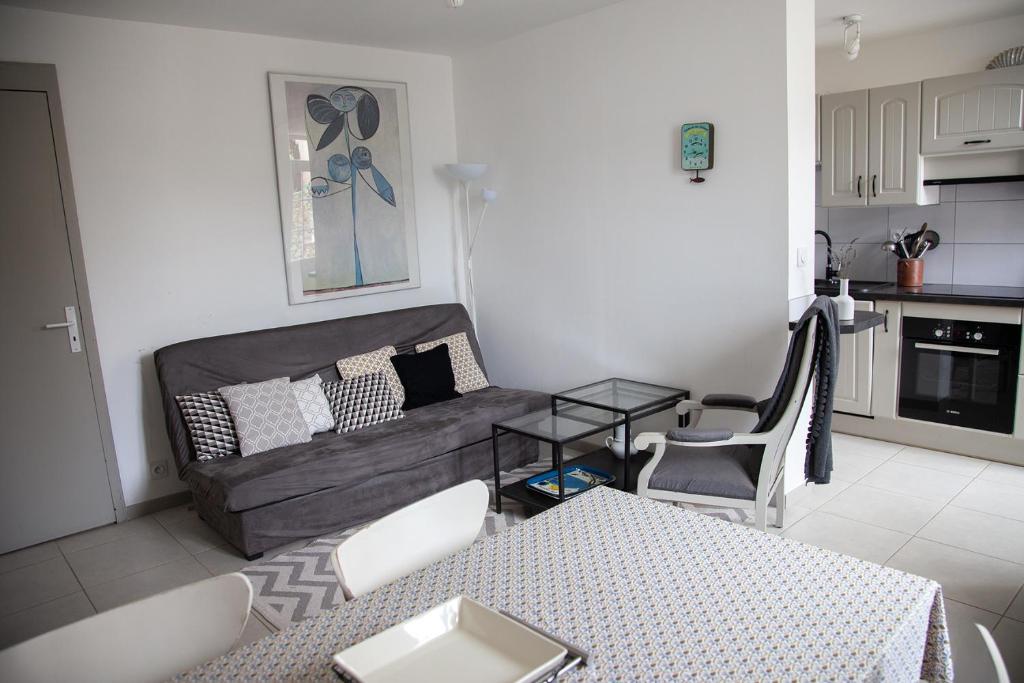 un salon avec un canapé et une table dans l'établissement Rez de chaussée, place du marché, plage à pied, à Pornichet