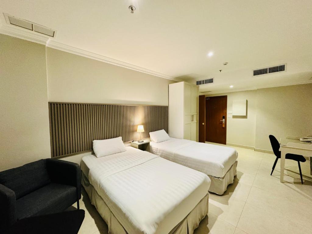 una camera d'albergo con due letti e un divano di Times Square Suite Hotel a Kuwait