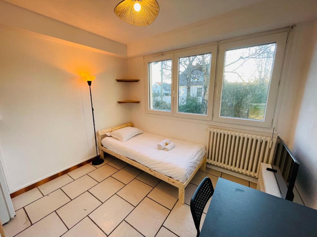 une petite pièce avec un lit et une table dans l'établissement Alyo, Studio proche centre 1p, à Caen