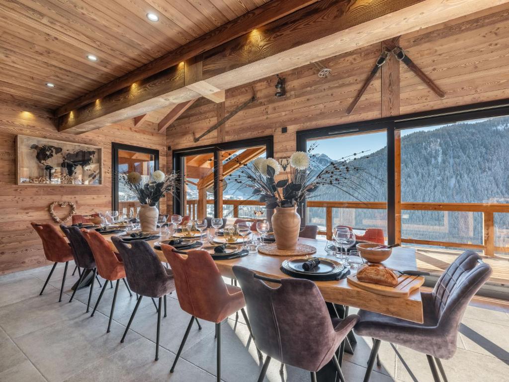 una sala da pranzo con un lungo tavolo e sedie di Chalet Mitoyen LA SAPINETTE - Bo Immobilier - remises sur les forfaits de skis Châtel ou Portes du soleil a Châtel
