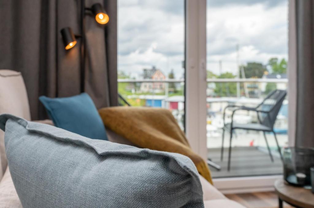 Hävenにある4Hafenzeiten - NIE7 Vorwärtsのソファがありバルコニーが見えるリビングルーム