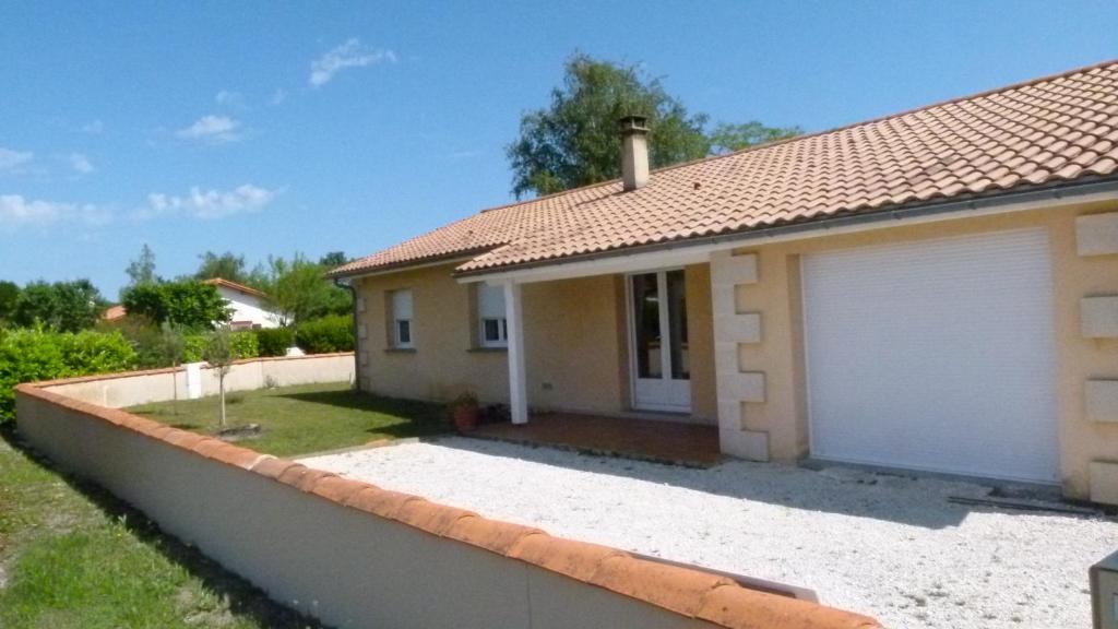 une petite maison avec un garage blanc dans l'établissement Les Calicots Sanguinet, à Sanguinet
