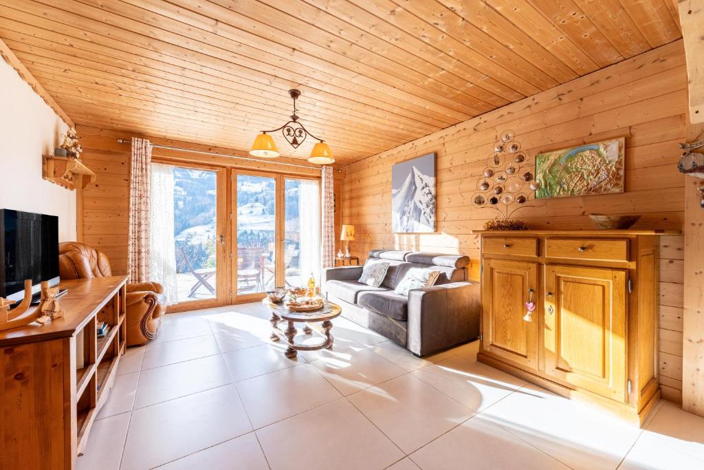 a living room with a couch and a tv at Tié No Appartement Chaleureux in Manigod