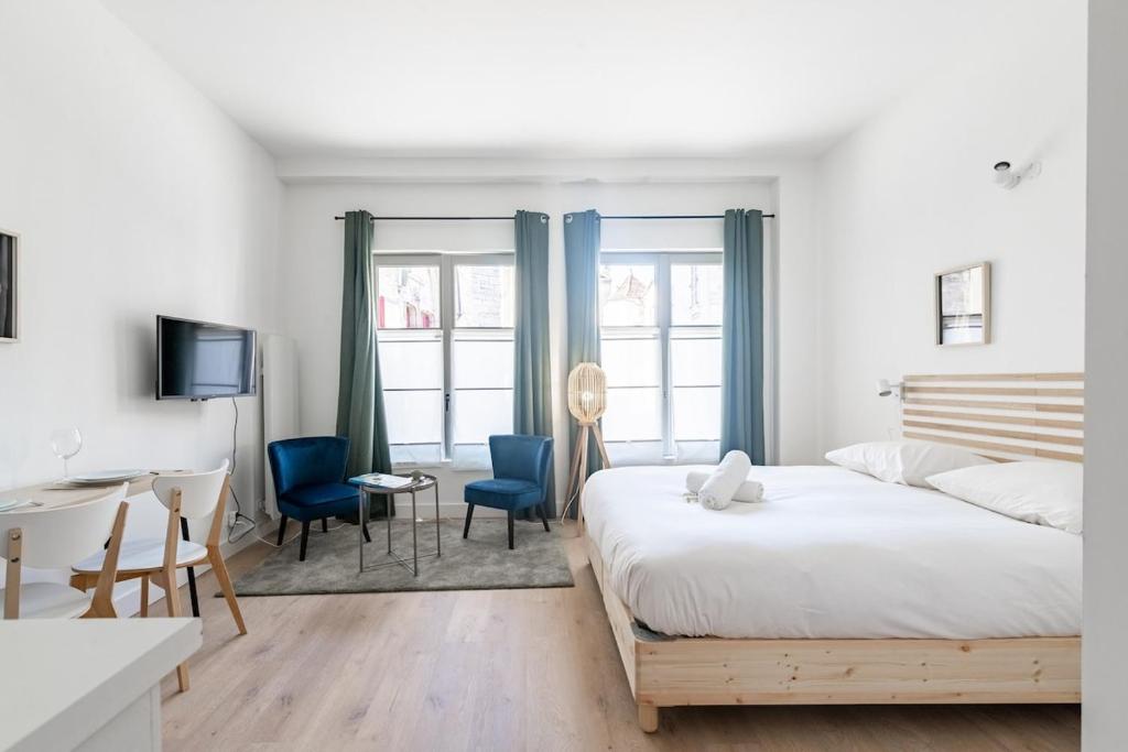 une chambre avec un lit, un bureau et des chaises dans l'établissement Le Hardi, à Dijon