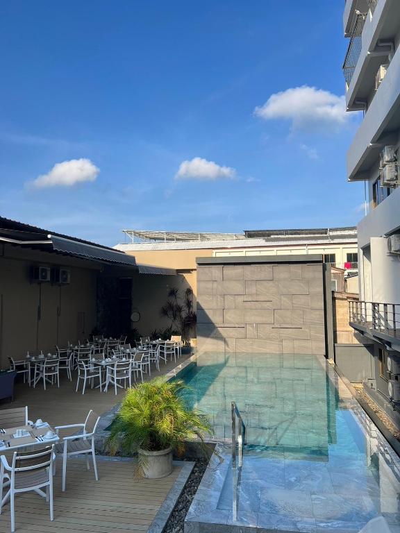 a hotel with a swimming pool with tables and chairs at Karon Boutique in Karon Beach