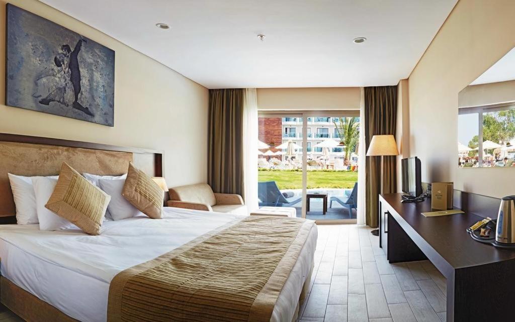 a hotel room with a large bed and a desk at My Ella Bodrum Resort & Spa in Peksimet