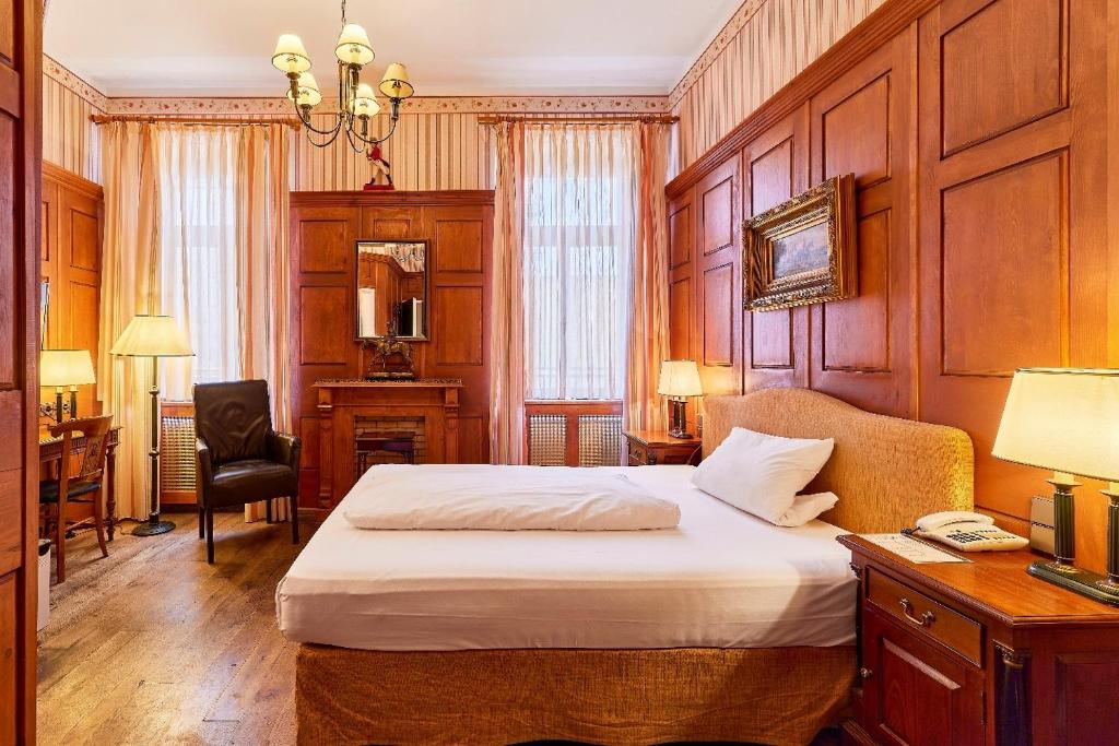 a bedroom with a bed and a desk and a chair at HIP Hotel in Heidelberg