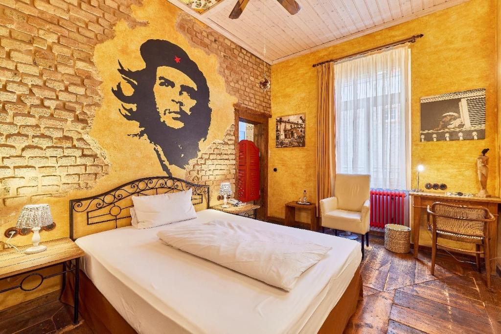 a bedroom with a bed with a painting on the wall at HIP Hotel in Heidelberg