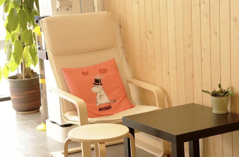 a chair with a cat pillow sitting on it at Jeju Orastay Hotel in Jeju