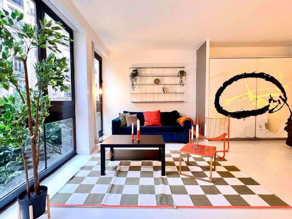 un salon avec un canapé bleu et une table dans l'établissement Spacious Apt Luxembourg 6 people, à Paris