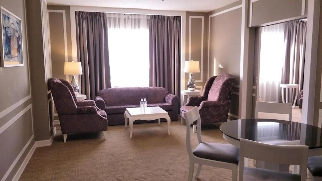 A formal sitting room with a sofa, armchairs, and a dining table.