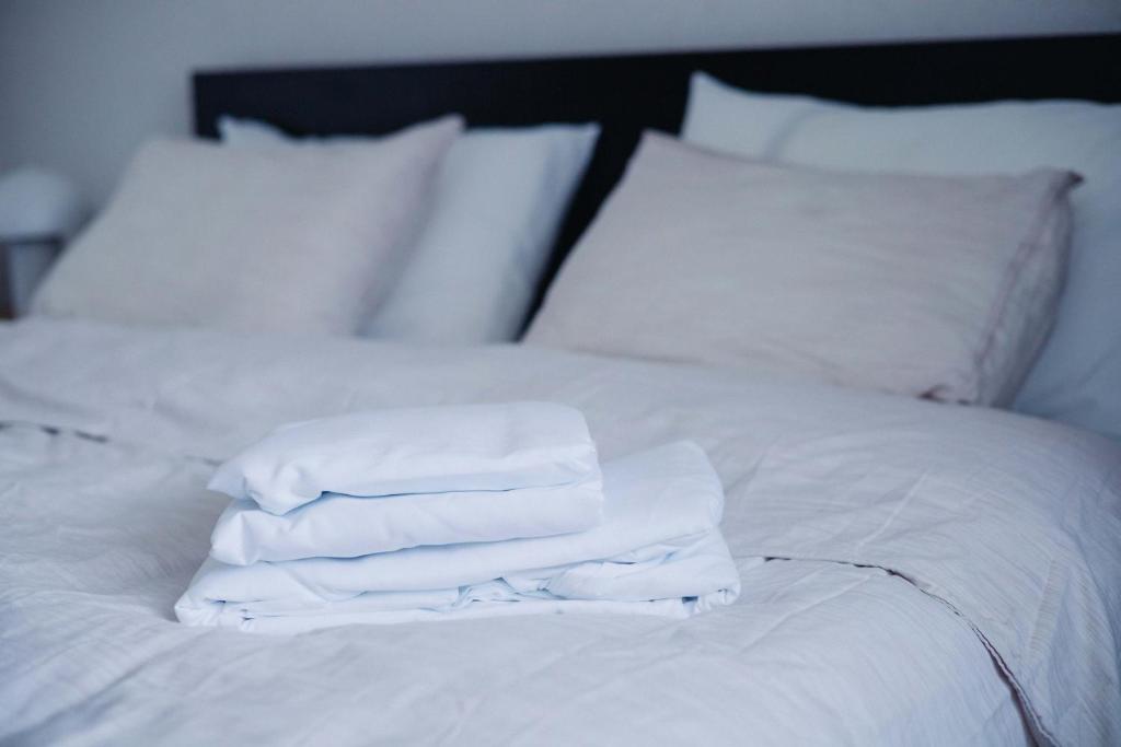 una pila di asciugamani bianchi appoggiata sopra un letto di Pirin Peaks Residence - next to Ski Lift a Bansko