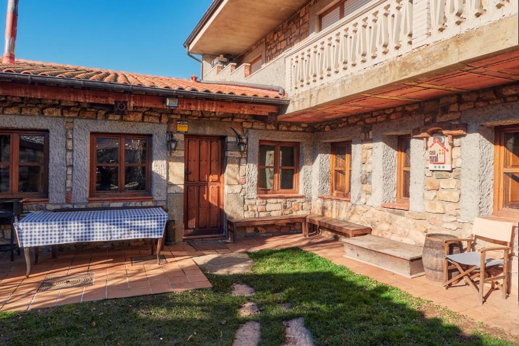 a patio of a house with a table and chairs at Aldaron in Boca de Huérgano