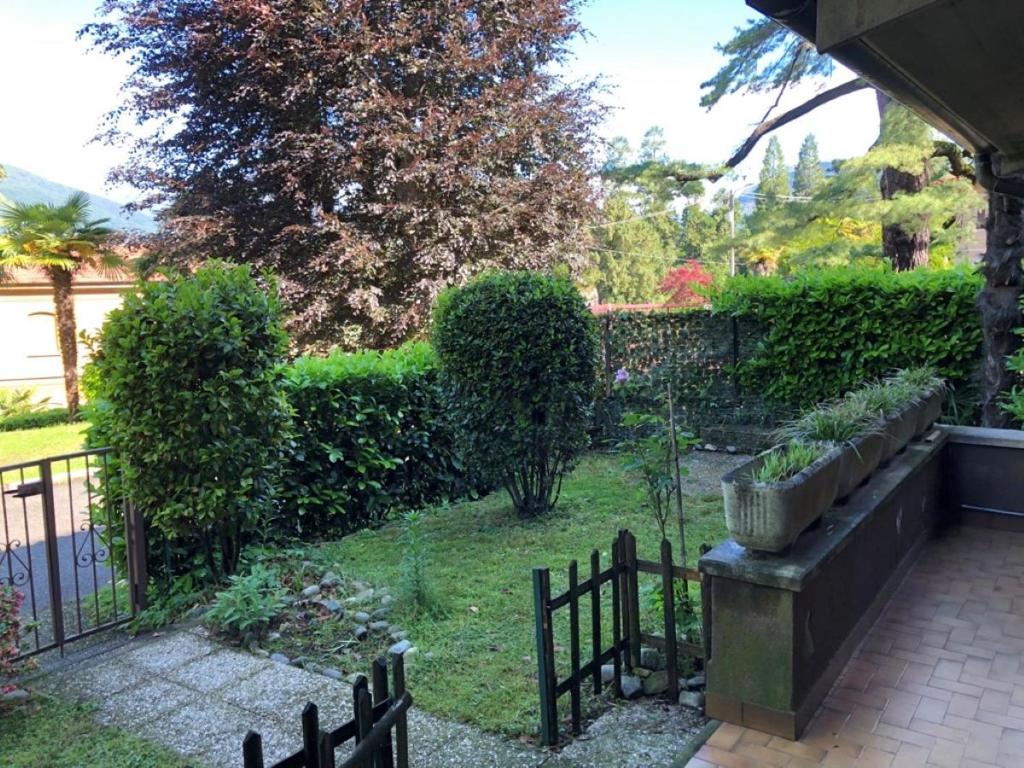 a garden with a fence and some bushes at Cordelia 9 Apartment in Luino