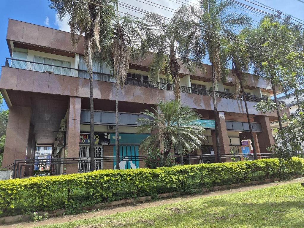 a building with palm trees in front of it at Flat Asa Norte CLN 311 by CentoEdez in Brasilia