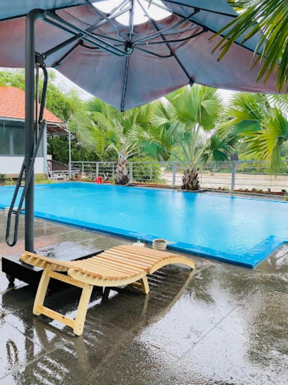 a table and an umbrella in front of a swimming pool at Dalis Waterfall Homestay in Lagi