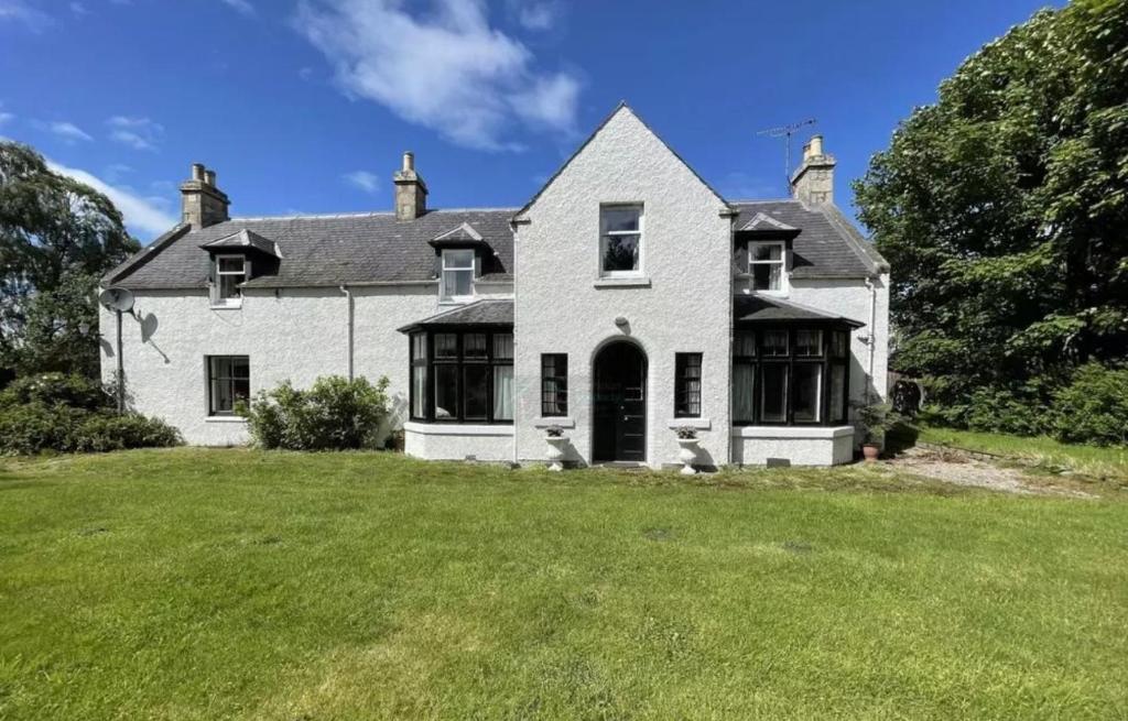 a large white house with a large yard at Woodside House in Crook of Alves