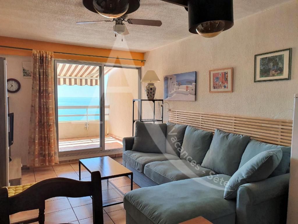 un salon avec un canapé et une vue sur l'océan dans l'établissement CONFORTABLE T2 EN FRONT DE MER, PARKING, WI-FI, à Sète