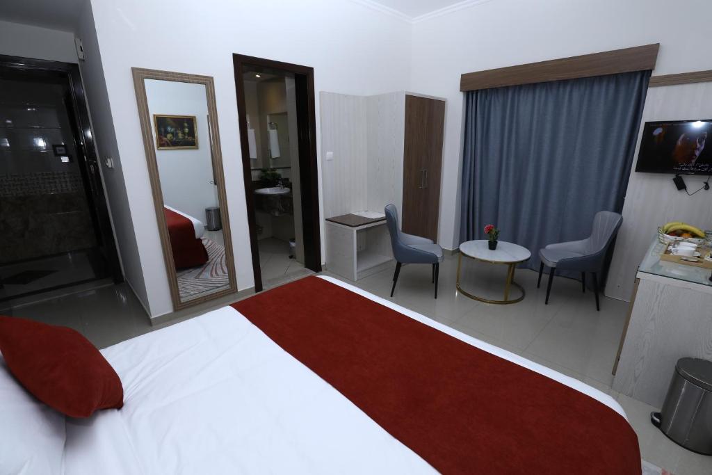 a hotel room with a bed and a table and chairs at Naif Fort Hotel in Dubai