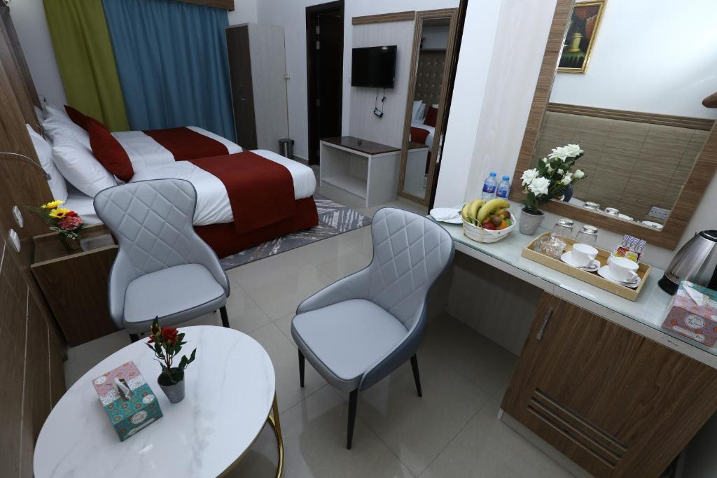 a hotel room with a bed and a table and chairs at Naif Fort Hotel in Dubai