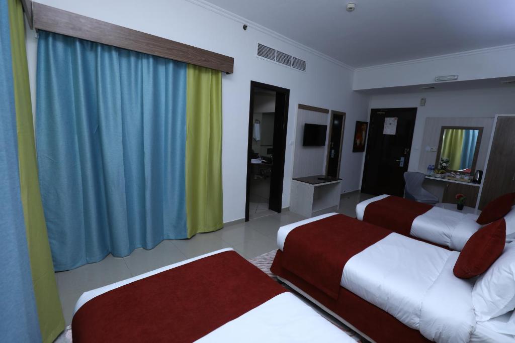 a hotel room with two beds and a television at Naif Fort Hotel in Dubai