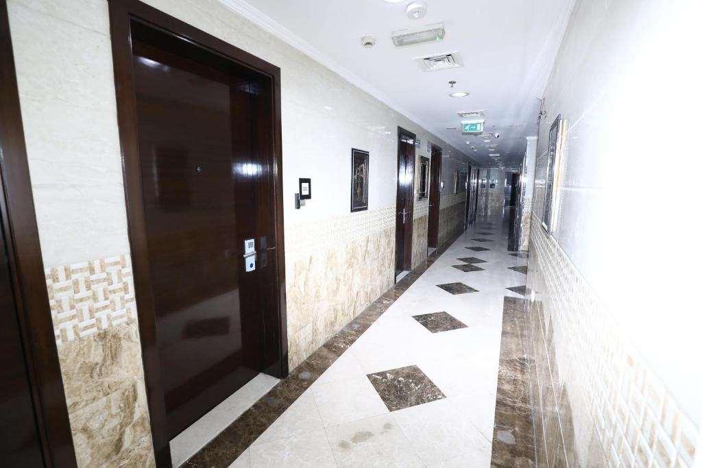 a corridor of a building with a door and tile floors at Naif Fort Hotel in Dubai