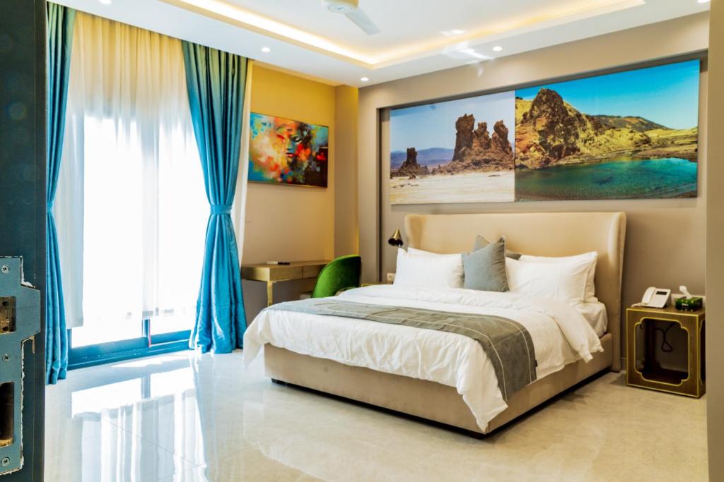 a bedroom with a bed with a large painting on the wall at The Villa Haramous in Djibouti