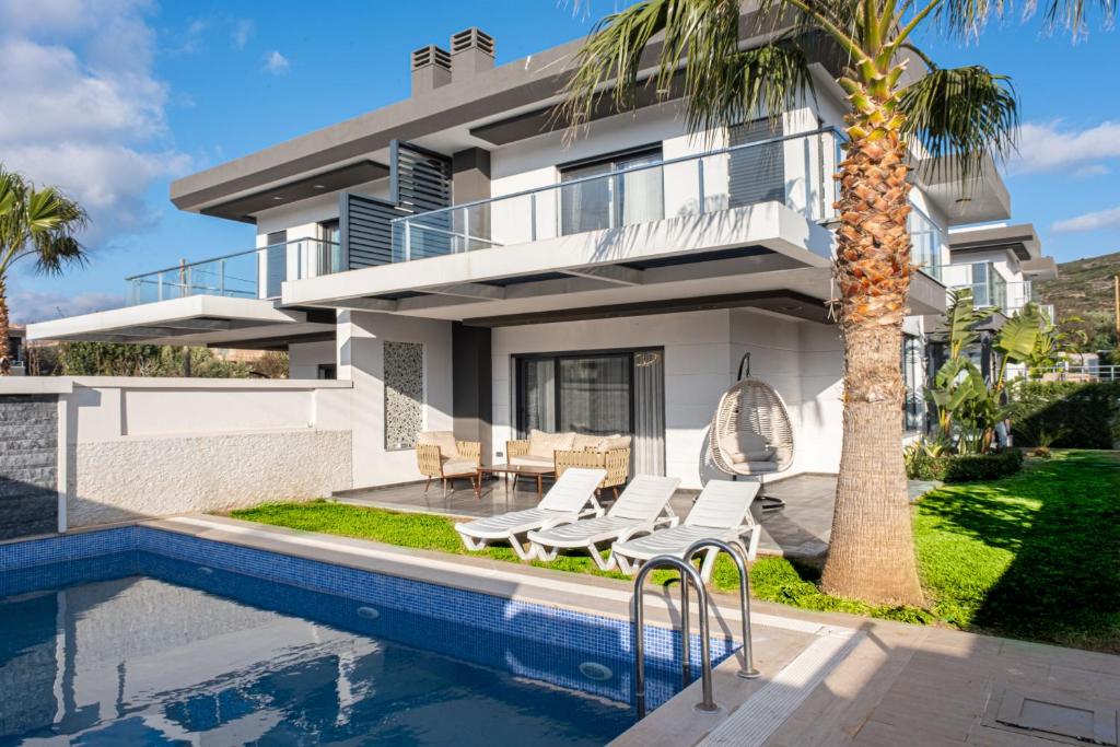una casa con piscina y una palmera en Çeşme lüks huzurlu yeni villa, en Cesme