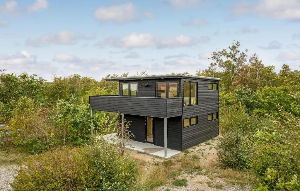 a black house in the middle of a field at Stunning Home In Grenaa With Sauna in Grenå