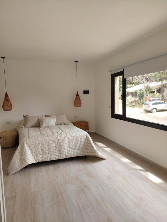 a bedroom with a bed and a large window at Senderos del Mar in Monte Hermoso