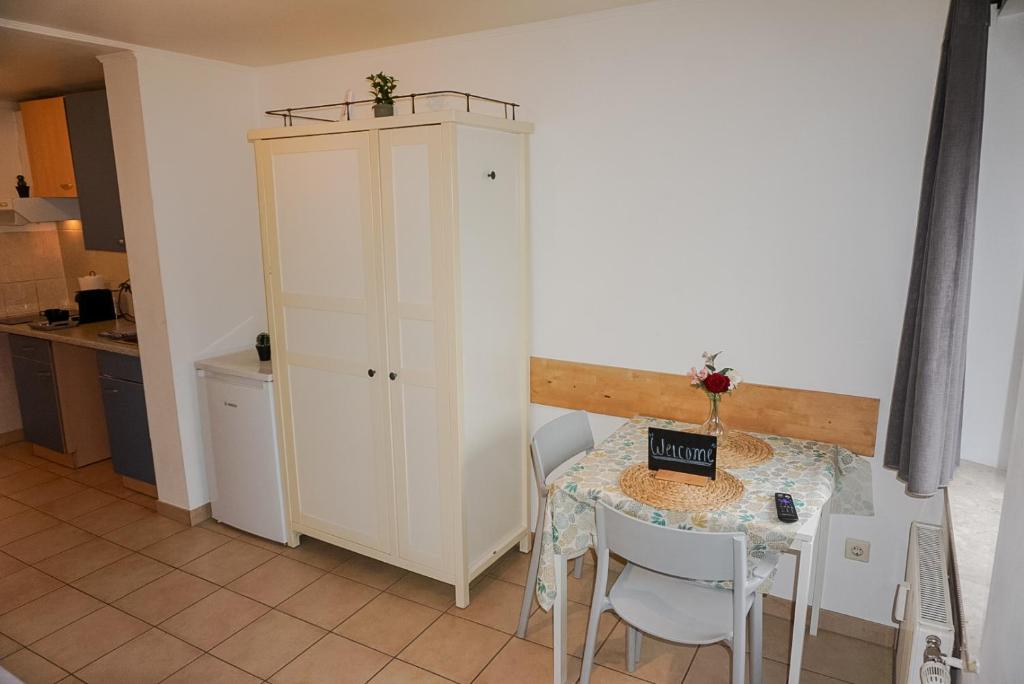 a kitchen with a table and a white cabinet at Apartment 71 Ettelbrück in Ettelbruck