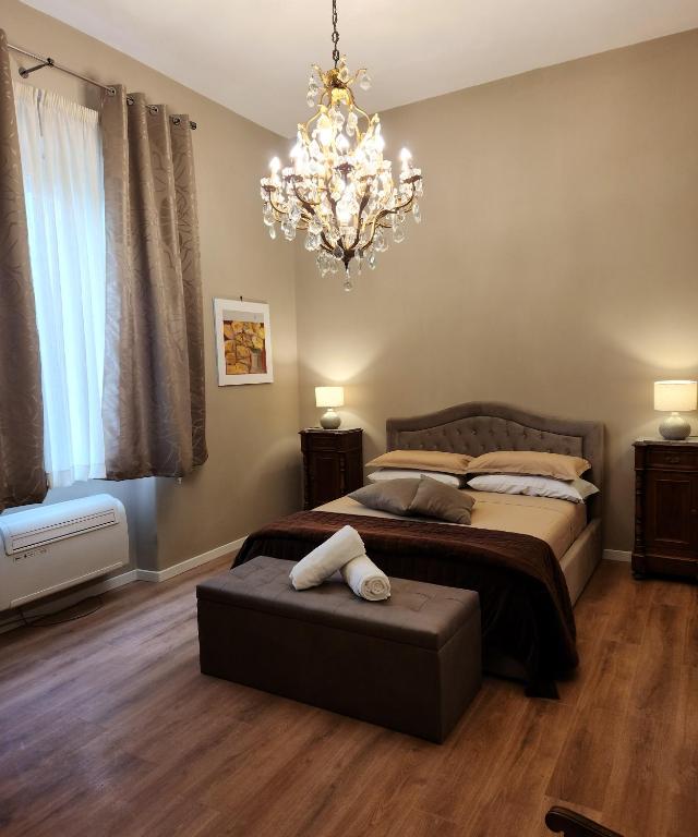 a bedroom with a large bed and a chandelier at Le Sale Resort in Caserta