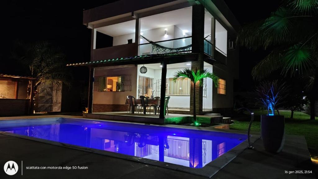 a house with a swimming pool at night at Casa Itacimirim in Camacari