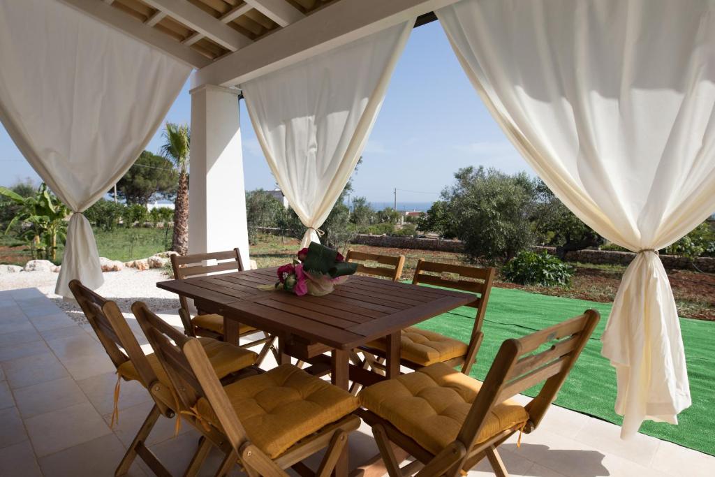 a wooden table and chairs on a patio at Bella Vista 33 - Cozy & VIP by Salento Prime in Marina di Pescoluse