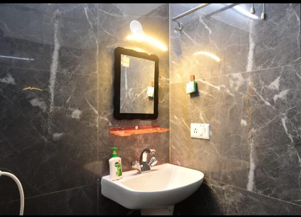 un baño con lavabo y espejo en saltlake inn, en kolkata
