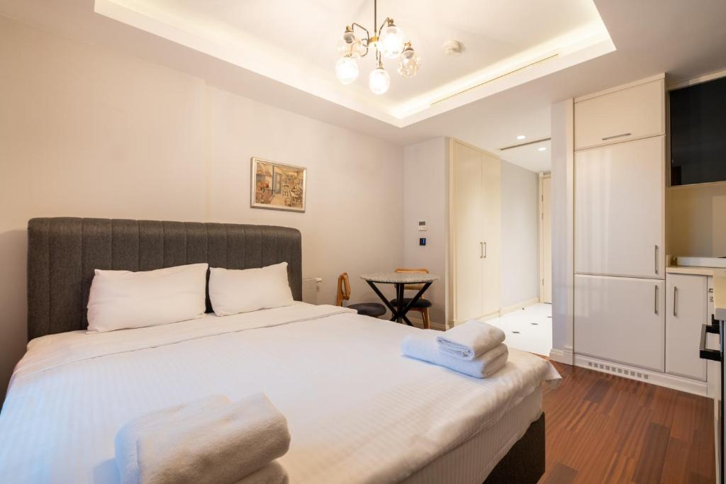 a bedroom with a large white bed and a kitchen at Luxury Apartments in Ofton Residence in Istanbul