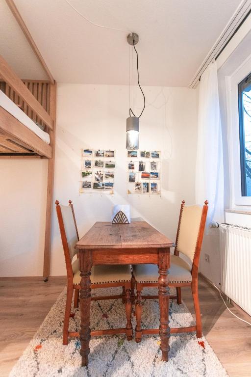 a dining room with a wooden table and chairs at Sam and Karo City Studio in Trier