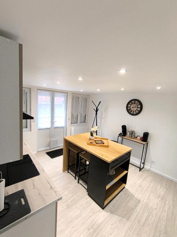 a kitchen with a desk and a clock on the wall at "Modern Cosy" Hyper centre in Bernay